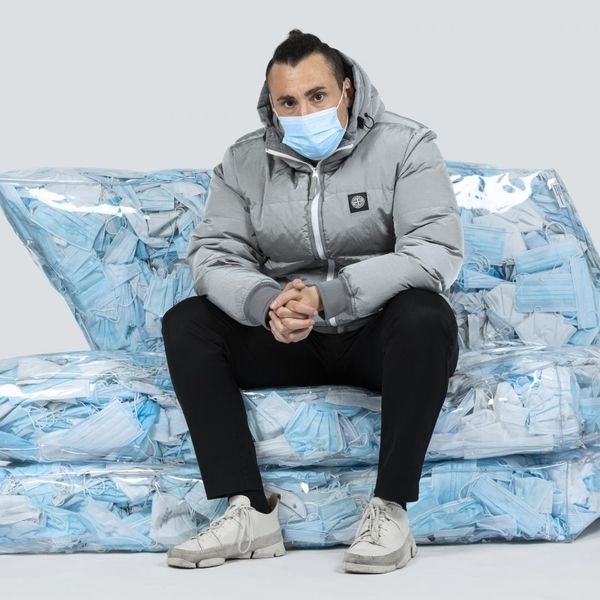 A couch stuffed with masks calls out wasteful living
