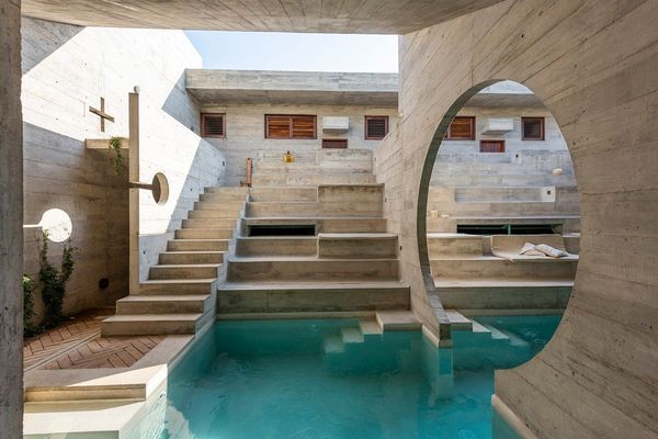 A Mexican hotel with a pool under its arches